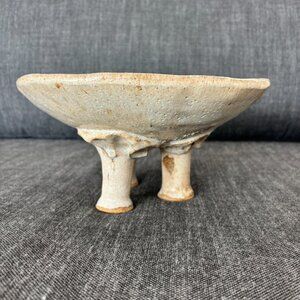 Hand-thrown, three-footed pottery bowl signed